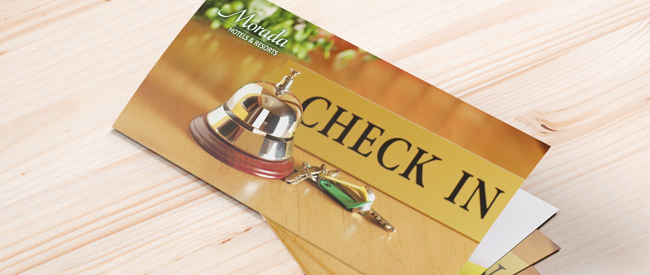 Einladendes Bild eines Check-in-Schalters mit einem Glocke und Schlüssel, beschriftet mit 'Morada Hotels & Resorts'.